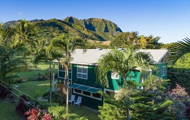 back of house featuring a lawn and a mountain view