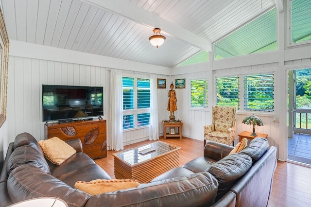 living room featuring vaulted ceiling with beams and light wood-type flooring