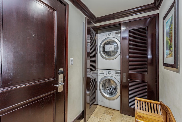 washroom featuring stacked washer and dryer and ornamental molding