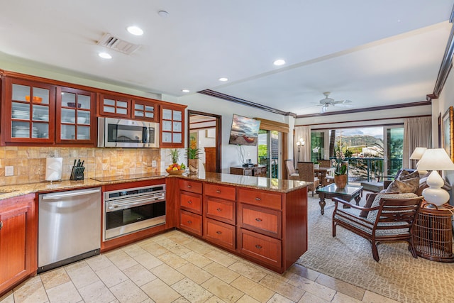 kitchen featuring kitchen peninsula, light stone counters, a healthy amount of sunlight, and appliances with stainless steel finishes