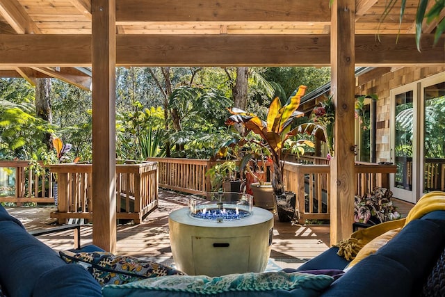 wooden terrace featuring an outdoor living space with a fire pit