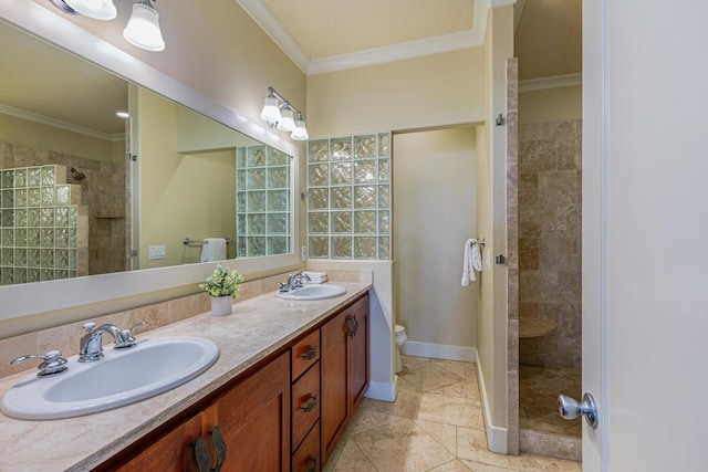 bathroom with crown molding, toilet, vanity, and tiled shower