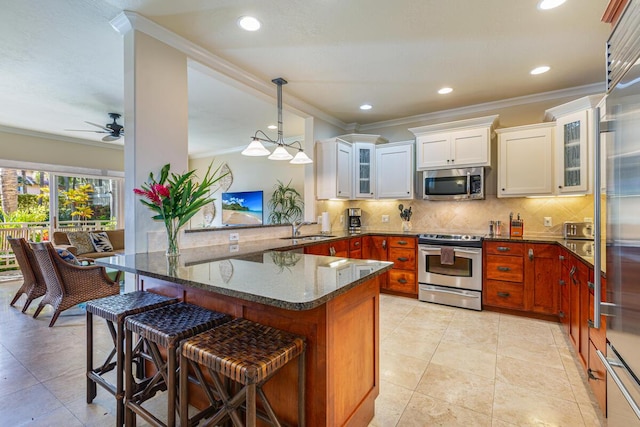 kitchen featuring kitchen peninsula, appliances with stainless steel finishes, a kitchen bar, sink, and white cabinetry