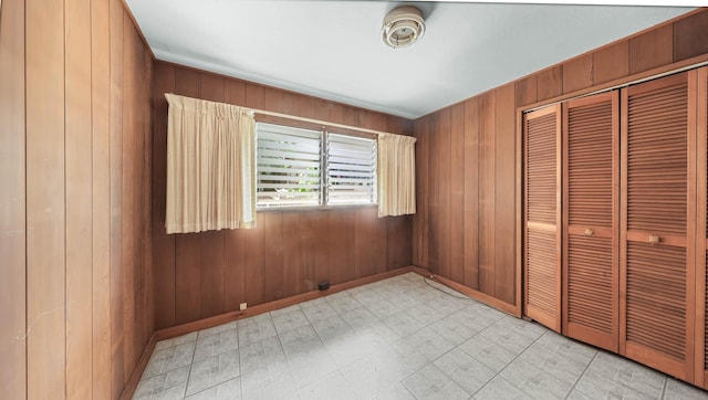 unfurnished bedroom with wooden walls and a closet