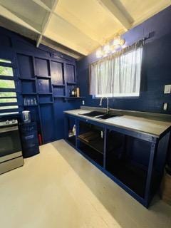 kitchen with blue cabinetry, vaulted ceiling, and sink