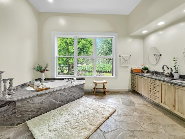 bathroom with a tub and vanity