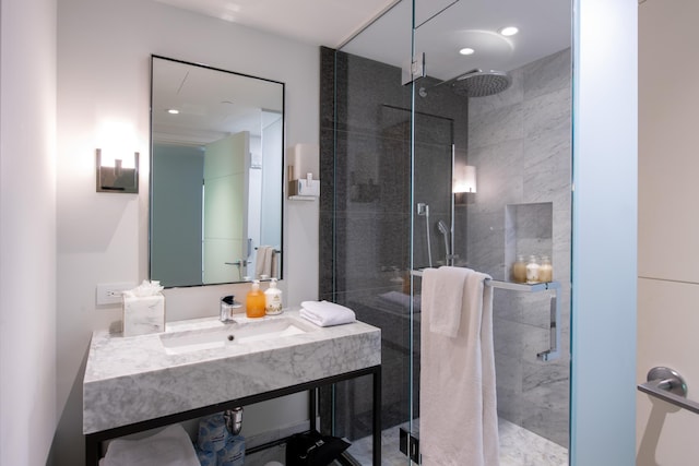 bathroom with sink and a shower with door