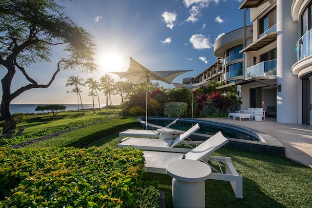 view of property's community featuring a pool, a patio area, and a lawn