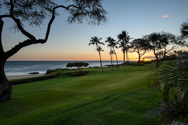 surrounding community with a yard and a water view