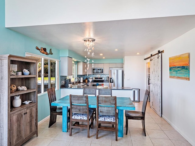 tiled dining space with a barn door and sink