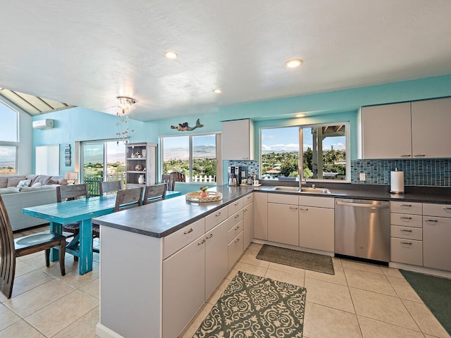 kitchen with kitchen peninsula, tasteful backsplash, sink, light tile patterned floors, and dishwasher