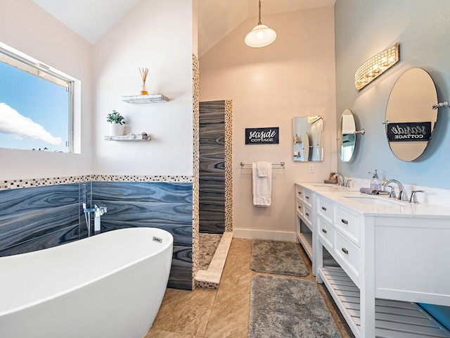 bathroom featuring a bathtub, vanity, and vaulted ceiling