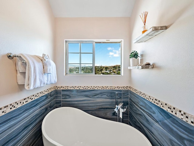 bathroom with a bath and tile walls