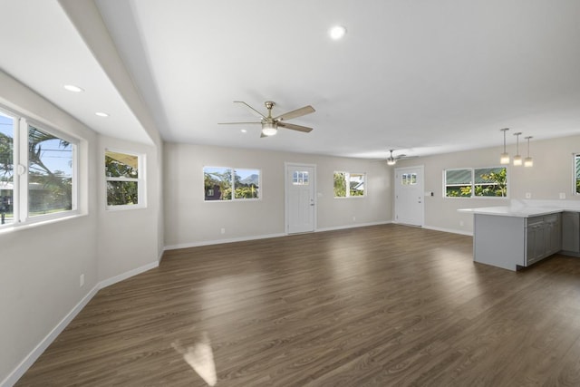 unfurnished living room featuring dark hardwood / wood-style floors and ceiling fan