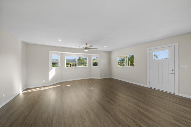 unfurnished living room with dark hardwood / wood-style flooring and ceiling fan