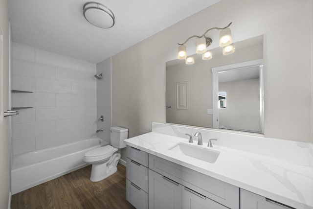 full bathroom featuring toilet, vanity, tiled shower / bath combo, and hardwood / wood-style flooring