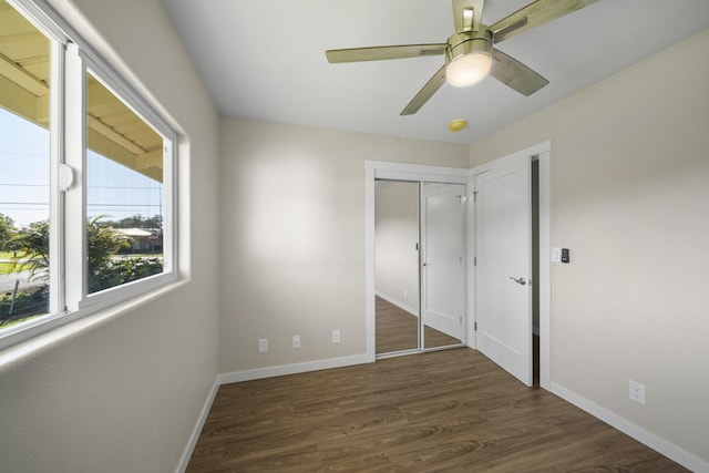 unfurnished bedroom featuring a closet, dark hardwood / wood-style floors, and ceiling fan