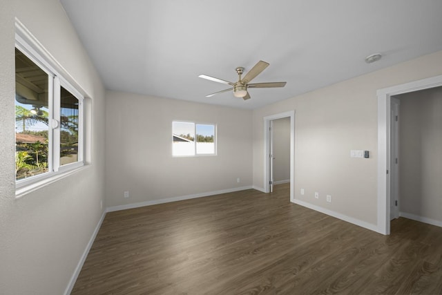 empty room with dark hardwood / wood-style flooring, ceiling fan, and a healthy amount of sunlight