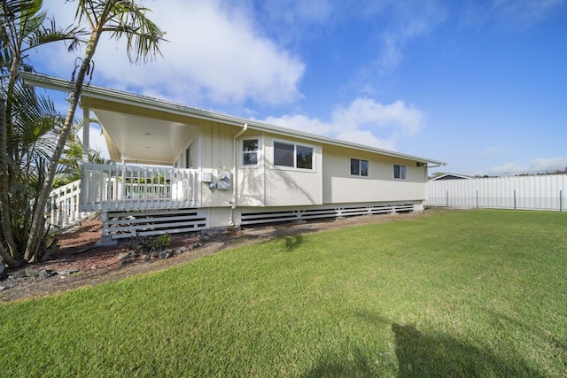 back of house with a lawn and a deck