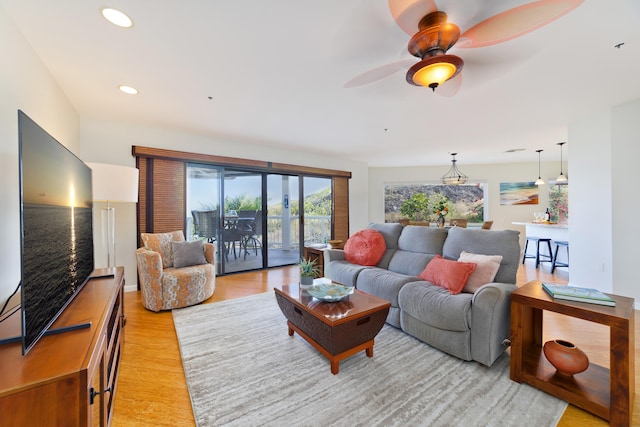 living room featuring ceiling fan and light hardwood / wood-style flooring