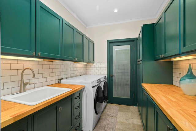 washroom featuring cabinets, independent washer and dryer, sink, and ornamental molding