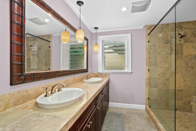 bathroom with a tile shower, vanity, and ornamental molding