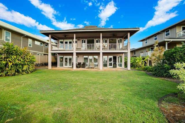 back of house with ceiling fan, a balcony, a yard, and a patio