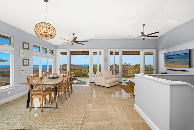 dining room with ceiling fan with notable chandelier and vaulted ceiling