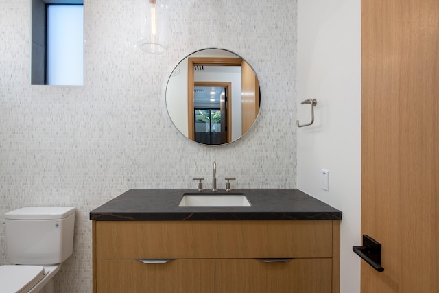 bathroom featuring backsplash, vanity, and toilet