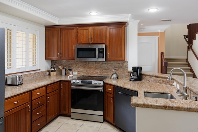 kitchen featuring light stone countertops, sink, backsplash, crown molding, and appliances with stainless steel finishes