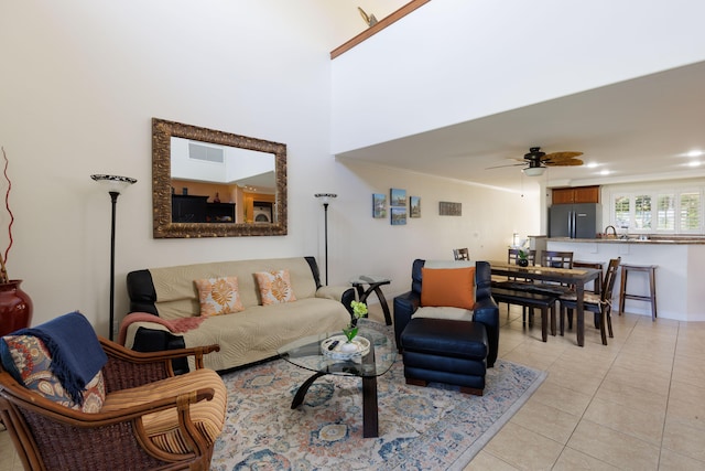 tiled living room with ceiling fan and ornamental molding