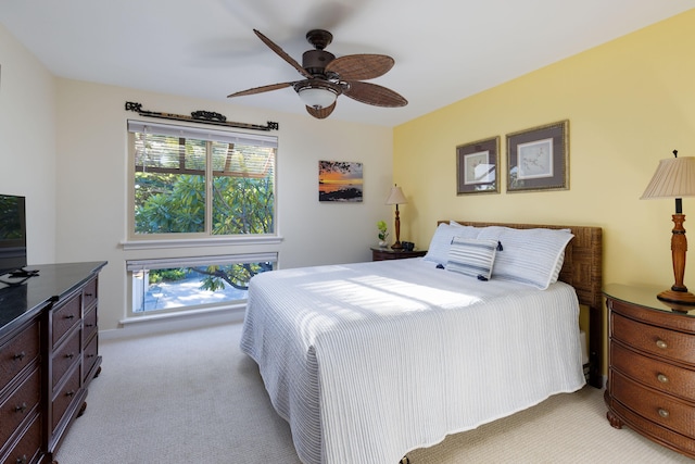 bedroom featuring multiple windows, light carpet, and ceiling fan