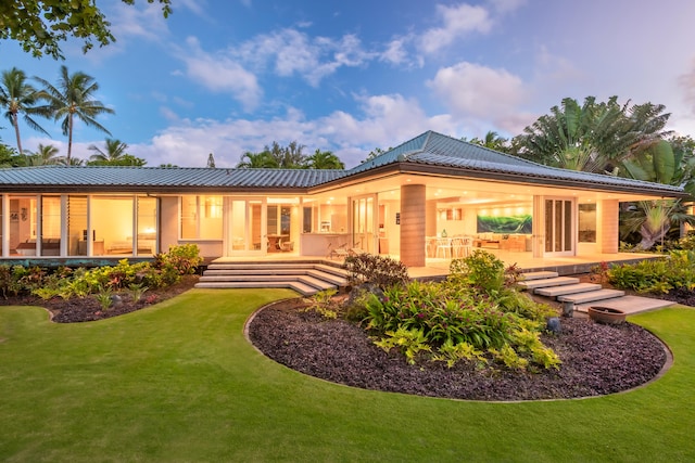 back house at dusk featuring a patio and french doors