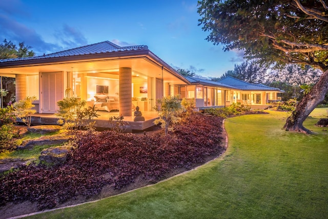 property exterior at dusk featuring a yard