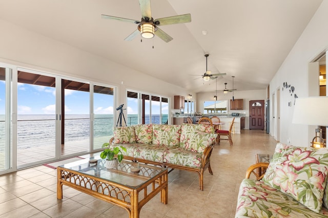 living room with a water view, ceiling fan, lofted ceiling, and light tile patterned flooring