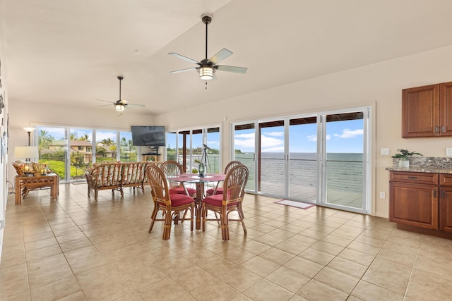 dining room featuring light tile patterned floors, plenty of natural light, ceiling fan, and lofted ceiling