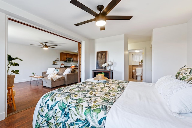 bedroom featuring ceiling fan, dark hardwood / wood-style floors, and ensuite bath