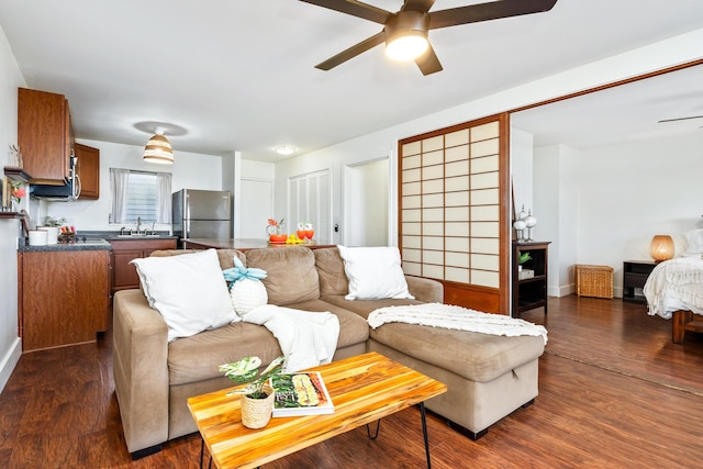 living room featuring dark hardwood / wood-style flooring, ceiling fan, and sink