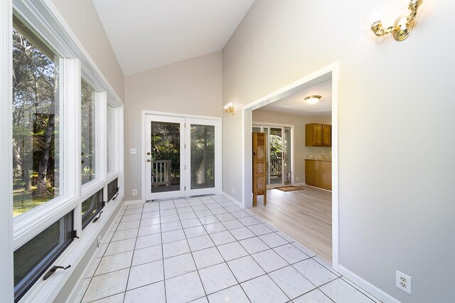 unfurnished sunroom featuring vaulted ceiling