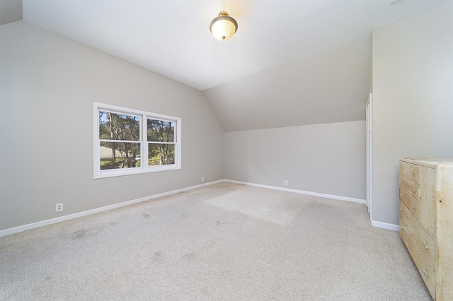 bonus room featuring vaulted ceiling and light colored carpet