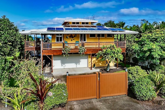 view of front facade featuring a garage, covered porch, and solar panels