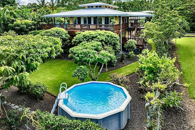 view of pool with a lawn and a wooden deck