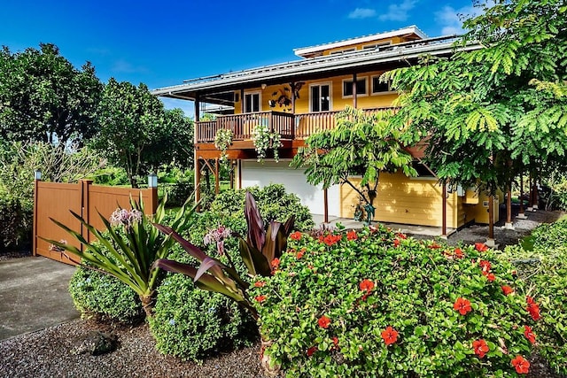 view of front of property featuring a balcony and a garage