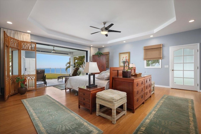 living area featuring a tray ceiling, plenty of natural light, and a water view