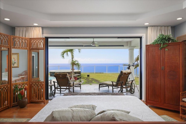 bedroom featuring light hardwood / wood-style floors and a water view