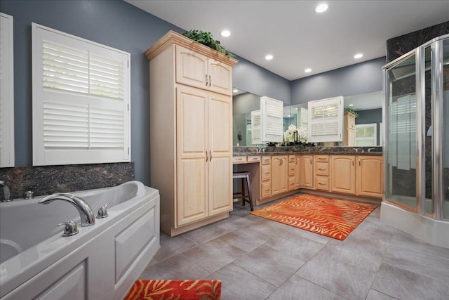 bathroom with plus walk in shower, vanity, and tile patterned flooring