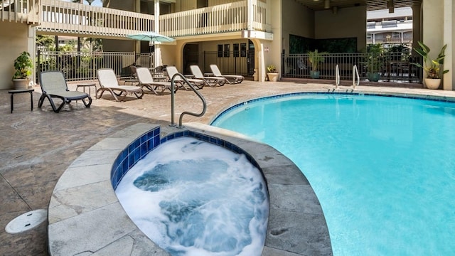 view of pool with a hot tub