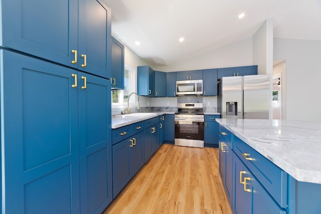 kitchen featuring stainless steel appliances, blue cabinets, sink, light hardwood / wood-style flooring, and lofted ceiling