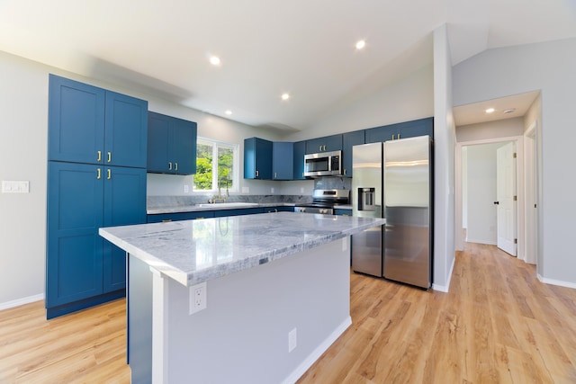 kitchen with light hardwood / wood-style floors, a center island, lofted ceiling, and appliances with stainless steel finishes