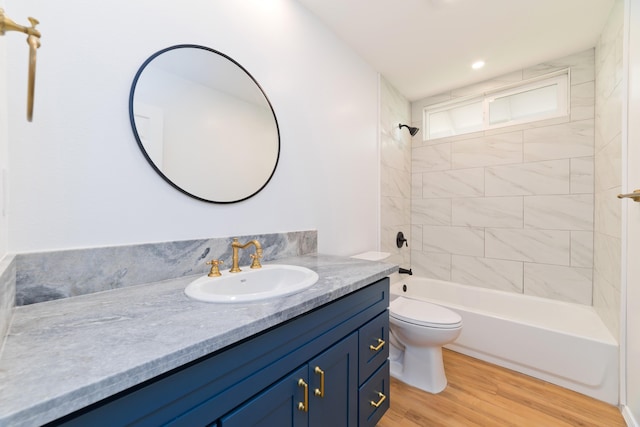 full bathroom with vanity, hardwood / wood-style floors, tiled shower / bath combo, and toilet